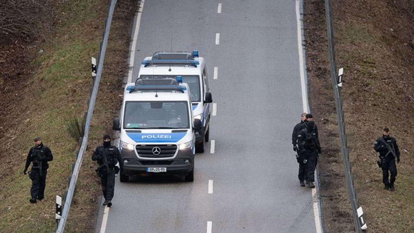 Polizisten suchen eine Straße in der Nähe des Tatorts ab
