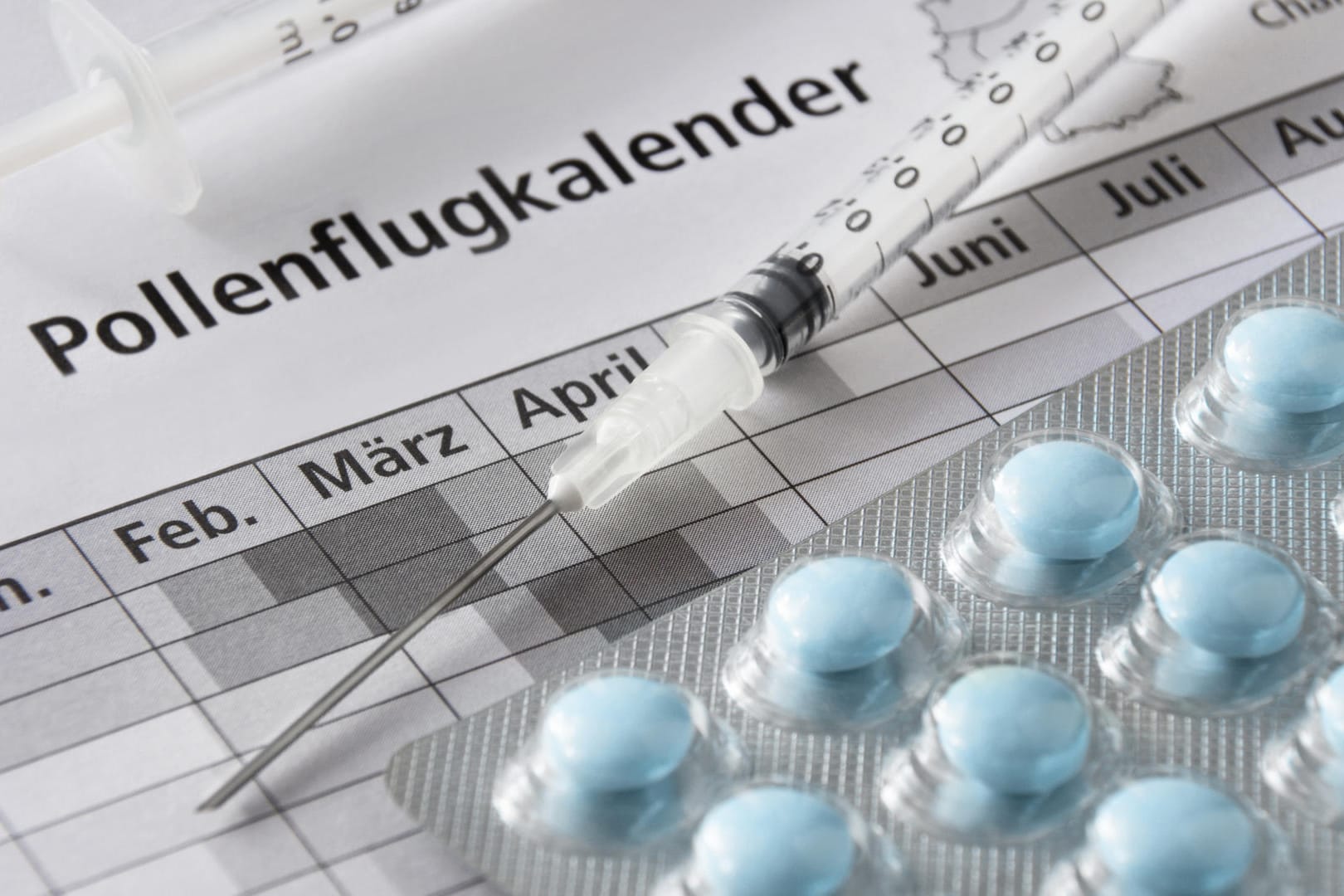 Pollenkalender mit Spritze und Tabletten: Mit der Hyposensibilisierung kann die Ursache einer Pollenallergie behandelt werden. Nach erfolgreicher Behandlung reagieren Betroffene nicht mehr allergisch.