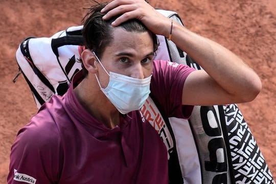 Tennisspieler Dominic Thiem fährt sich durch die Haare als er nach einem Spiel den Platz verlässt.