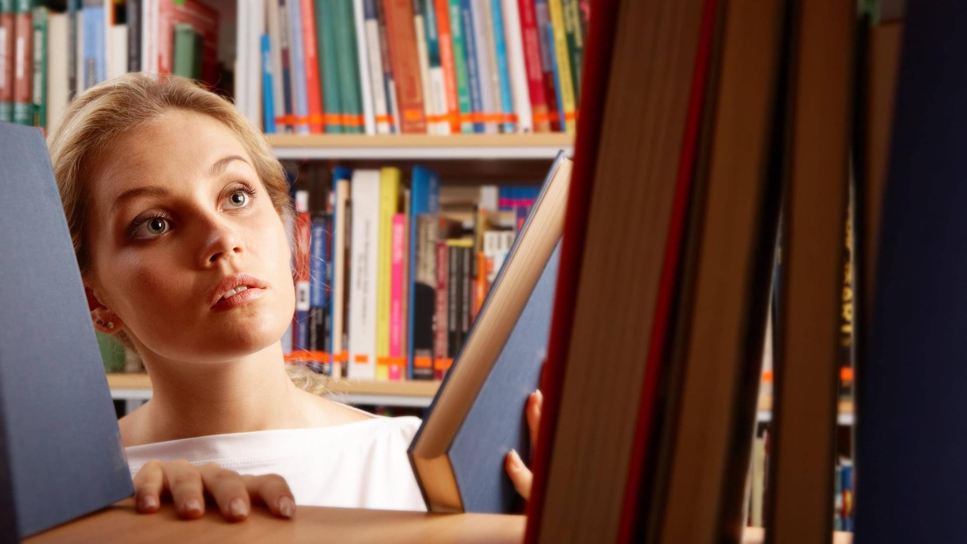 Junge Frau informiert sich in der Bibliothek