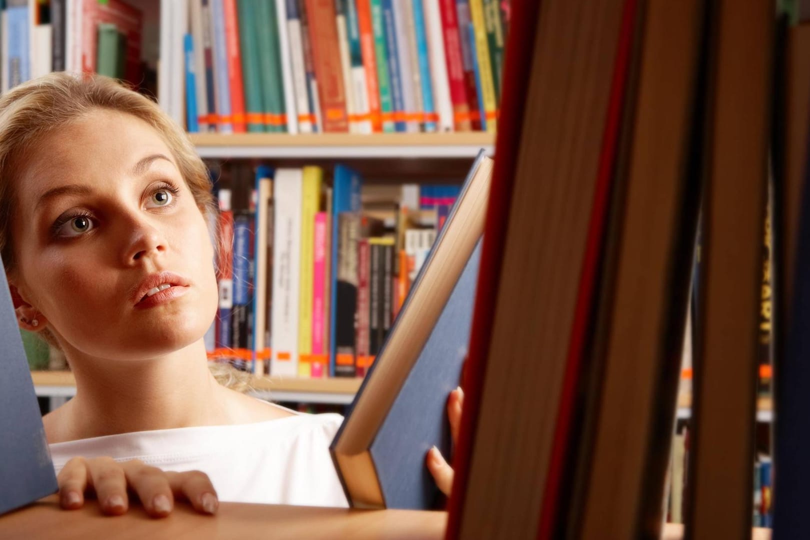 Junge Frau informiert sich in der Bibliothek