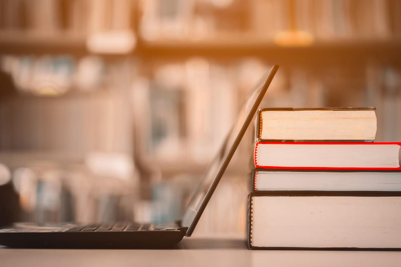 Bookshelves and laptops are placed on the library desk.E-learning class and e-book digital technology