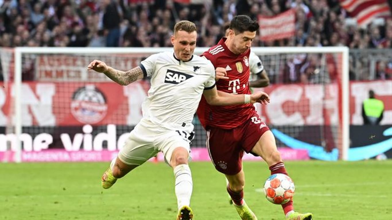 Hoffenheims David Raum (l) im Duell mit Bayern-Star Robert Lewandowski.