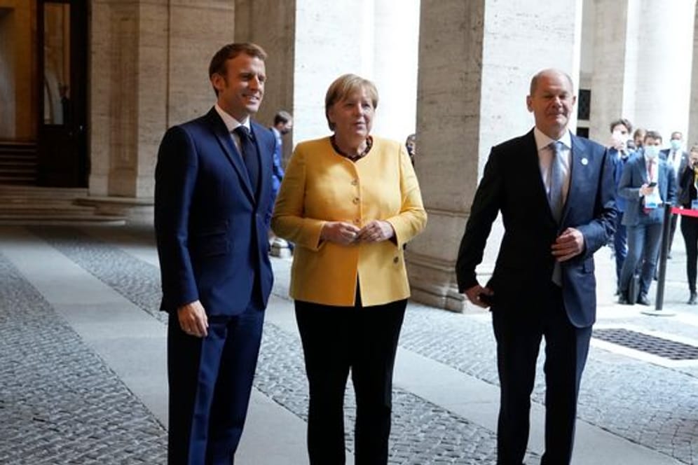 Emmanuel Macron (l-r), Präsident von Frankreich, begrüßt Angela Merkel (CDU), geschäftsführende Bundeskanzlerin, und Olaf Scholz (SPD), Bundesfinanzminister und Kanzlerkandidat, vor einem Treffen der Europäischen Union und der Afrikanischen Union in der französischen Botschaft.