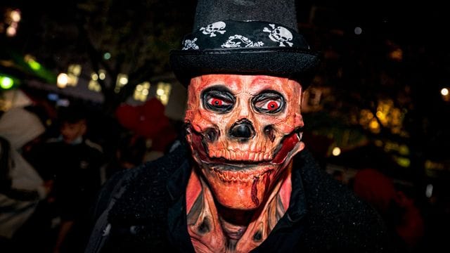 Ein Mann mit einer Totenkopf-Maske und glühenden roten Augen bei der Essener Halloween-Parade.