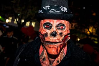 Ein Mann mit einer Totenkopf-Maske und glühenden roten Augen bei der Essener Halloween-Parade.