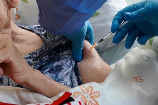 Eine Heimbewohnerin einer Seniorenresidenz in Sachsen-Anhalt erhält ihre Drittimpfung gegen das Corona-Virus.