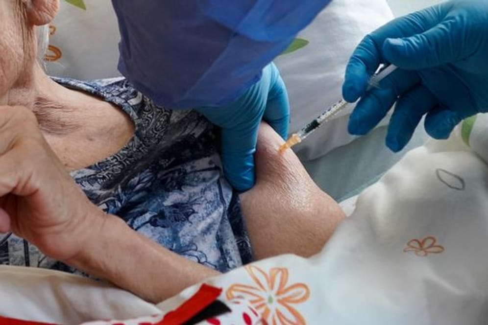 Eine Heimbewohnerin einer Seniorenresidenz in Sachsen-Anhalt erhält ihre Drittimpfung gegen das Corona-Virus.