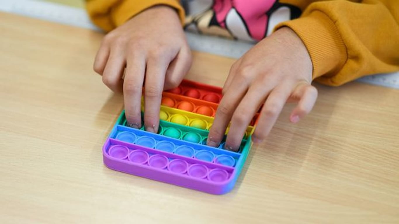 In einem Klassenzimmer einer Bielefelder Grundschule spielt ein Kind mit Pop-Its.
