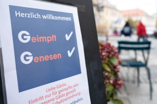 Eine Tafel vor einem Restaurant an der Hauptstraße informiert die Gäste über die 2G-Regel mit der Aufschrift „Geimpft Genesen“.