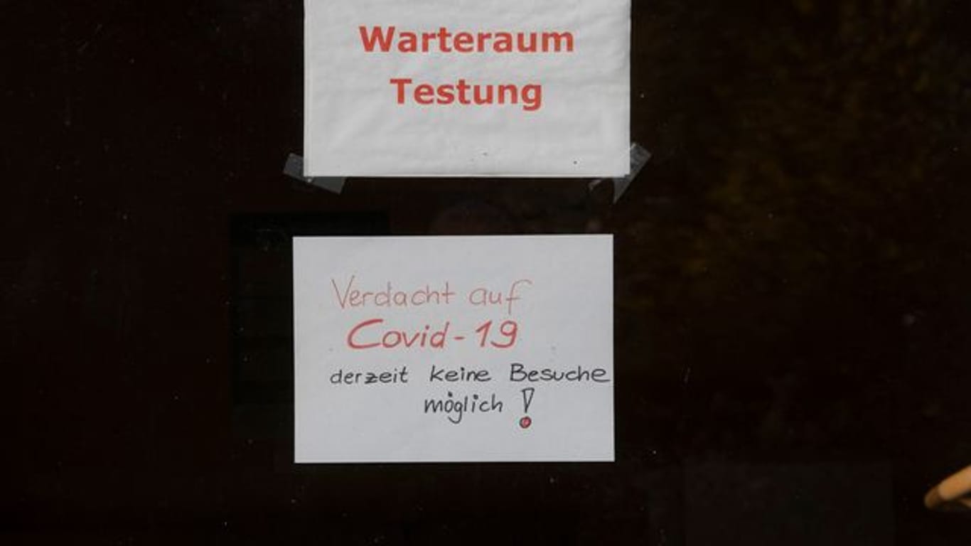 "Warteraum Testung" und "Verdacht auf Covid-19 derzeit keine Besuche möglich!" steht auf Zetteln an einer Scheibe in dem Seniorenheim, in dem es zum Corona-Ausbruch gekommen ist.