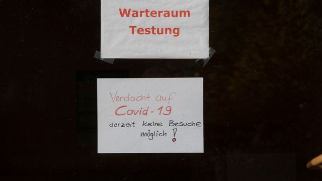 "Warteraum Testung" und "Verdacht auf Covid-19 derzeit keine Besuche möglich!" steht auf Zetteln an einer Scheibe in dem Seniorenheim, in dem es zum Corona-Ausbruch gekommen ist.