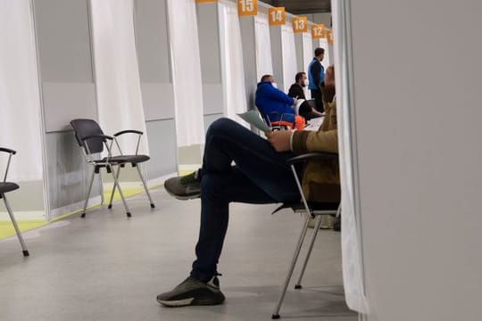 Menschen warten im Malteser-Impfzentrum unter dem Messeturm in Berlin auf ihre Impfung.