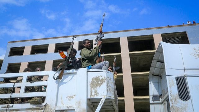 Bewaffnete Tigray-Streitkräfte begleiten gefangene äthiopische Regierungssoldaten und verbündete Milizangehörige in offenen Lastwagen in eine Haftanstalt. Bewaffnete Tigray-Streitkräfte begleiten gefangene äthiopische Regierungssoldaten und verbündete Milizangehörige in offenen Lastwagen in eine Haftanstalt.