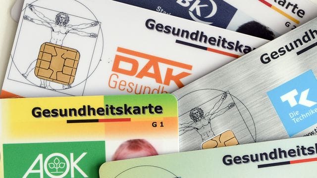 Gesundheitskarten verschiedener Krankenkassen liegen auf einem Tisch. Gesundheitskarten verschiedener Krankenkassen liegen auf einem Tisch.