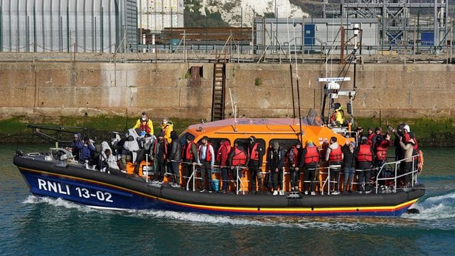 Eine Gruppe von Menschen, bei denen es sich vermutlich um Migranten handelt, wird von Grenzpolizisten nach Dover gebracht.