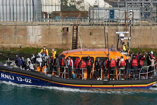 Eine Gruppe von Menschen, bei denen es sich vermutlich um Migranten handelt, wird von Grenzpolizisten nach Dover gebracht.