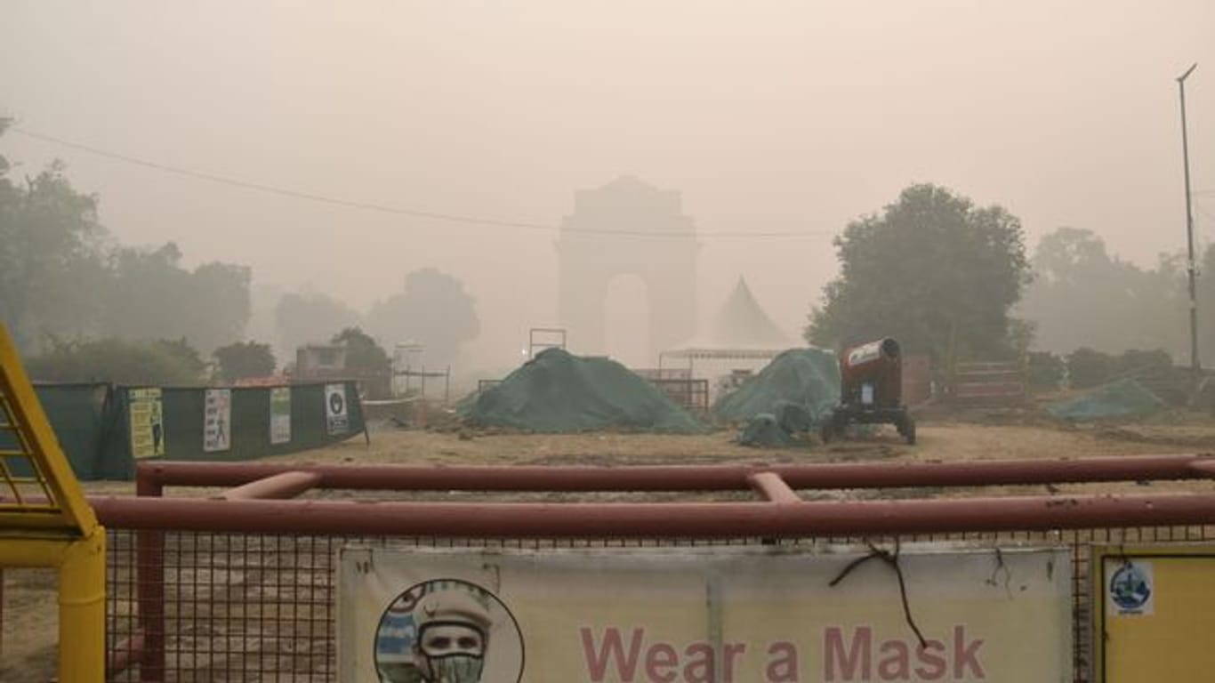 Das India Gate in Neu Delhi ist im Smog hinter einer Baustelle nur schwach zu sehen.