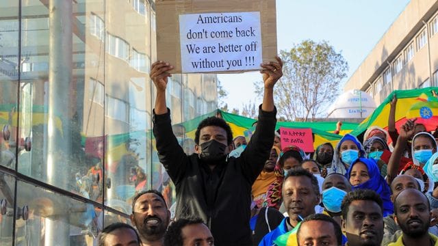 Ein Protestteilnehmer mit einem Transparent, auf dem zu lesen ist "Amerikaner, kommt nicht zurück. Ein Protestteilnehmer mit einem Transparent, auf dem zu lesen ist "Amerikaner, kommt nicht zurück.