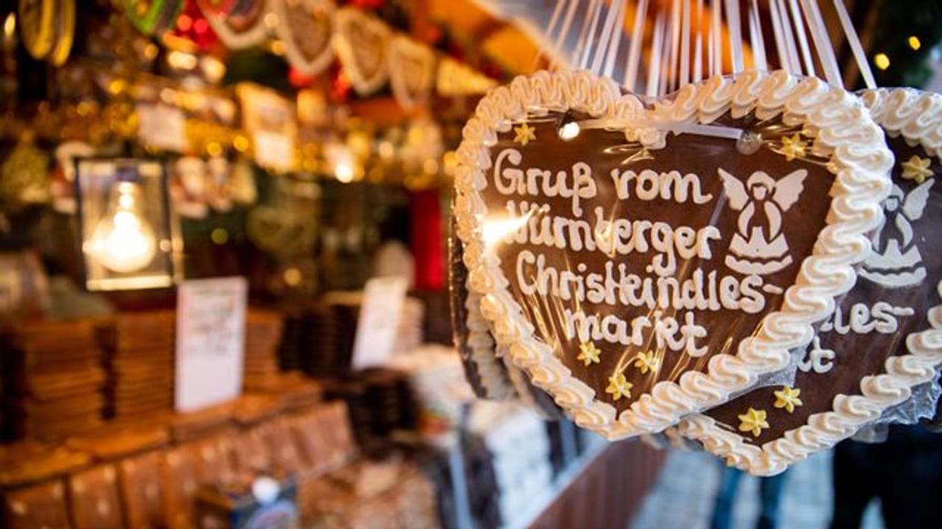 Lebkuchenherzen mit der Aufschrift "Gruß vom Nürnberger Christkindlesmarkt" hängen an einem Stand auf dem Nürnberger Christkindlesmarkt.