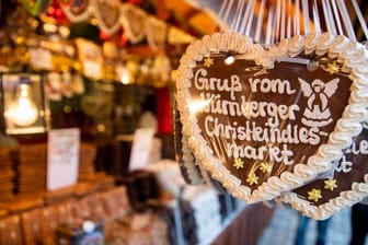 Lebkuchenherzen mit der Aufschrift "Gruß vom Nürnberger Christkindlesmarkt" hängen an einem Stand auf dem Nürnberger Christkindlesmarkt.