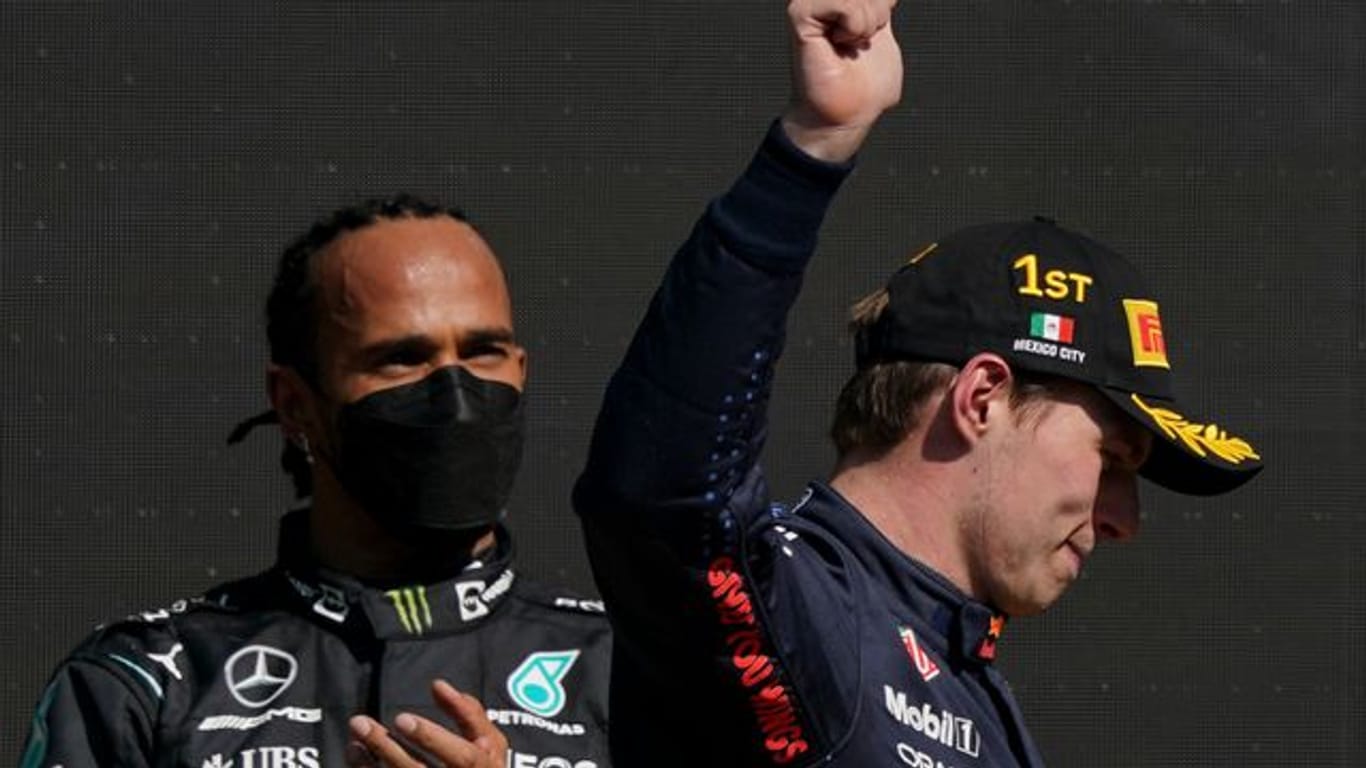 Max Verstappen (r) feiert seinen Sieg, während der zweitplatzierte Lewis Hamilton zuschaut.