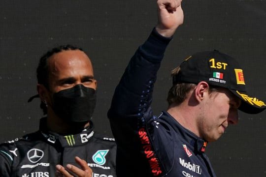 Max Verstappen (r) feiert seinen Sieg, während der zweitplatzierte Lewis Hamilton zuschaut.