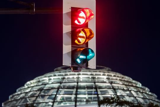 Rot-gelb-grün - eine Ampel leuchtet vor der Kuppel des Reichstagsgebäudes (in einer Langzeitbelichtung) in allen drei Phasen.