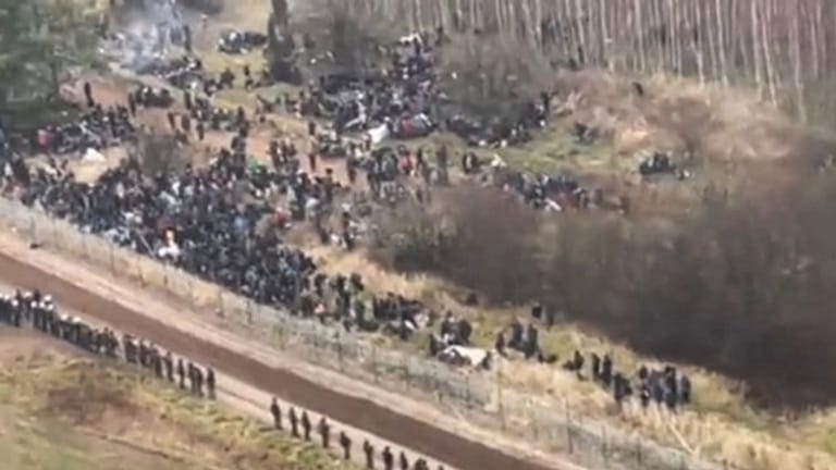 Ein TV-Bild zeigt Migranten auf dem Weg zur belarussisch-polnischen Grenze.