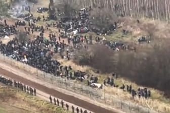 Ein TV-Bild zeigt Migranten auf dem Weg zur belarussisch-polnischen Grenze.