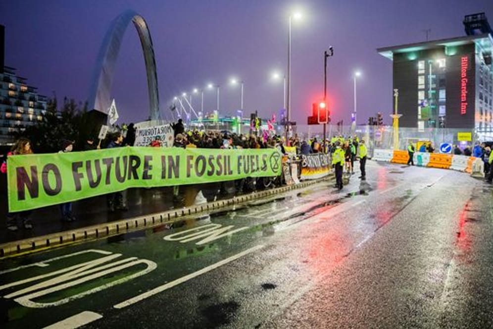 Menschen protestieren am Rande der UN-Klimakonferenz COP26 in Glasgow für besseren Klimaschutz.