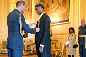 Prinz William (l), Herzog von Cambridge, verleiht Marcus Rashford während einer Zeremonie auf Schloss Windsor einen Orden.
