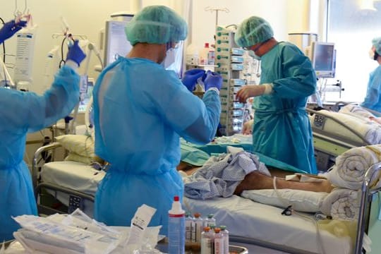 Auf der Covid-Station vom Universitätsklinikum Leipzig versorgen Ärzte, Schwestern und Pfleger einen Patienten.