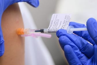 Eine Ärztin impft im Universitätsklinikum in Dresden einen Arztkollegen mit der dritten Impfung gegen das Coronavirus.