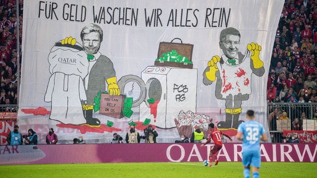 Mit einem Transparent "Für Geld waschen wir alles rein" protestieren Bayern-Fans gegen die Geschäftsbeziehungen mit Katar.