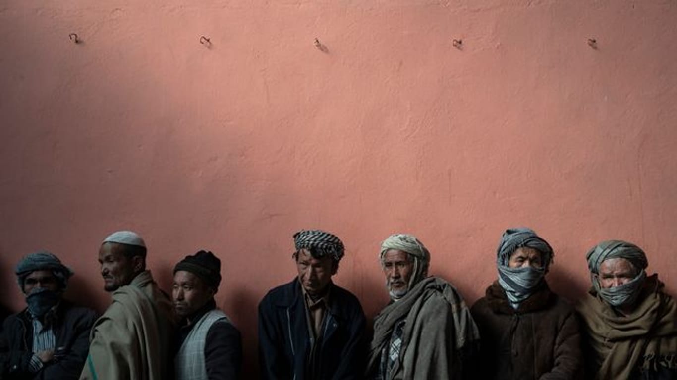Männer warten in einer Schlange, um bei einer vom Welternährungsprogramm (WFP) organisierten Geldverteilung Bargeld zu erhalten.