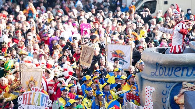 Menschenmassen jubeln dem Düsseldorfer Hoppeditz (r) zu.