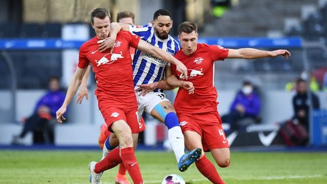 Leipzigs Lukas Klostermann (l) und Willi Orban (r) in Aktion gegen Matheus Cunha von Hertha BSC.