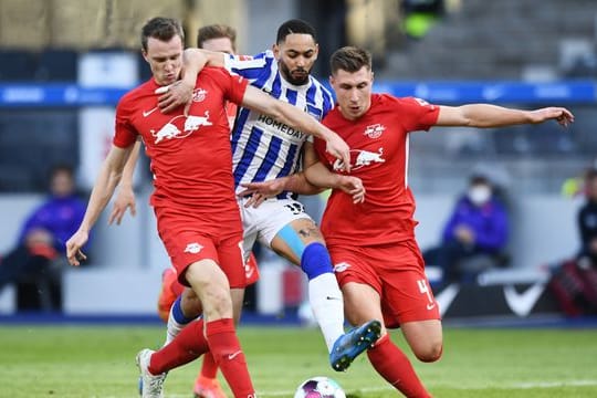 Leipzigs Lukas Klostermann (l) und Willi Orban (r) in Aktion gegen Matheus Cunha von Hertha BSC.