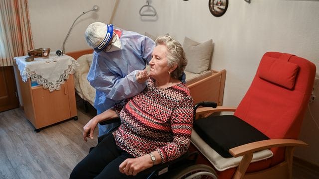 Die Krankenschwester eines mobilen Test-Teams des Deutschen Roten Kreuzes (DRK) testet in einer DRK-Seniorenbetreuungseinrichtung in Brandenburg eine Seniorin. Die Krankenschwester eines mobilen Test-Teams des Deutschen Roten Kreuzes (DRK) testet in einer DRK-Seniorenbetreuungseinrichtung in Brandenburg eine Seniorin.