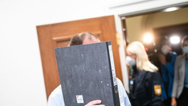 Der Angeklagte versteckt sein Gesicht beim Prozessauftakt hinter einem Ordner. Der Angeklagte versteckt sein Gesicht beim Prozessauftakt hinter einem Ordner.