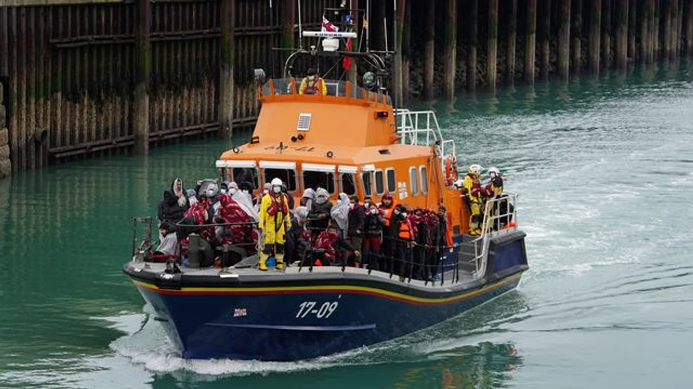Eine Gruppe von Menschen, bei denen es sich vermutlich um Migranten handelt, wird an Bord des Dover-Rettungsboots an Land gebracht.