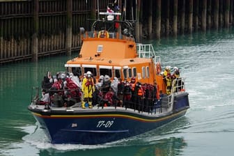 Eine Gruppe von Menschen, bei denen es sich vermutlich um Migranten handelt, wird an Bord des Dover-Rettungsboots an Land gebracht.