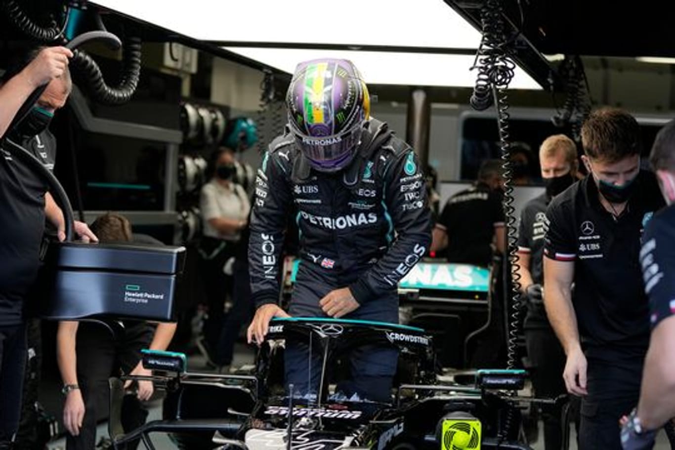 Der britische Mercedes-Pilot Lewis Hamilton steigt in seinen Rennwagen.
