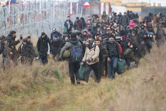 Migranten am Stacheldrahtzaun an der belarussisch-polnischen Grenze.