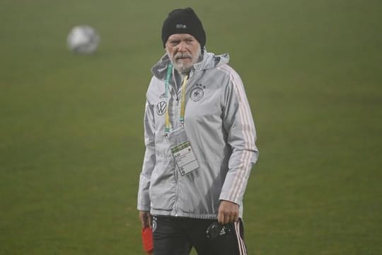 Co-Trainer Hermann Gerland geht vor einem Spiel der deutschen U21 über den Platz.