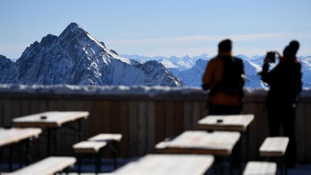 Zwei Besucher fotografieren von der Zugspitze aus das Panorama des Wettersteingebirges. Zwei Besucher fotografieren von der Zugspitze aus das Panorama des Wettersteingebirges.