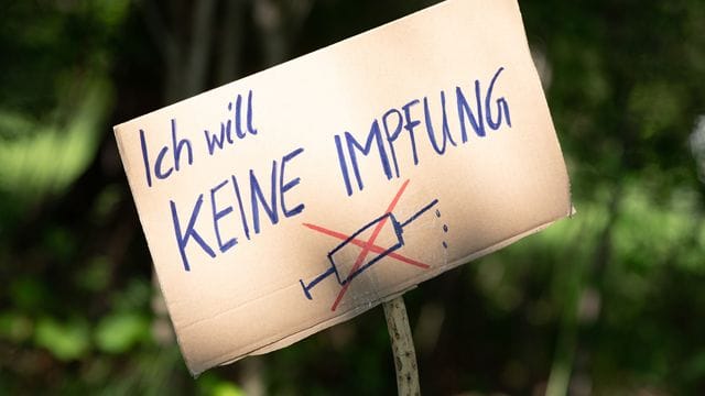 Ein Schild mit der Aufschrift "Ich will keine Impfung" am Rande einer Kundgebung in Dresden.