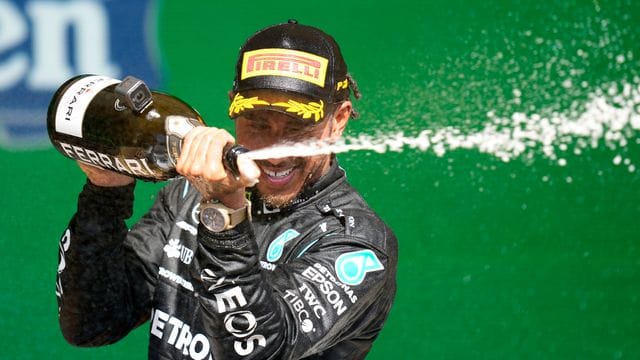 Lewis Hamilton feiert auf dem Podium seinen Erfolg.