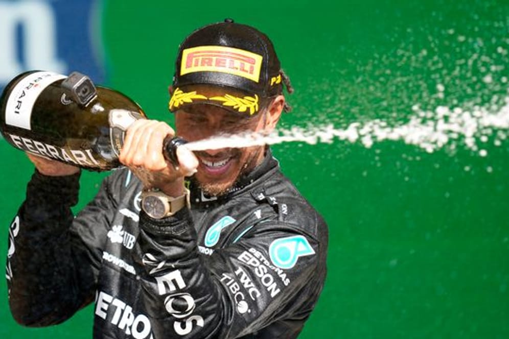 Lewis Hamilton feiert auf dem Podium seinen Erfolg.